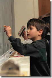 students writing on chalkboard