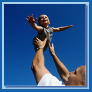 Father lifting baby in the air.